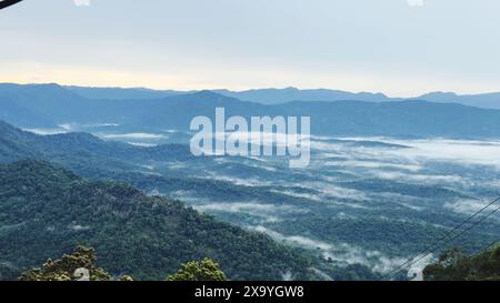 Berggipfel, die von Nebel und Wolken verdeckt sind, durch ein Fenster gesehen Stockfoto