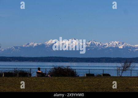 Person, die sich auf einem See mit Bergkulisse entspannt Stockfoto