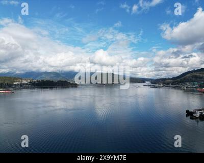 Ein ruhiger See mit zahlreichen Booten, umgeben von Bäumen und einem majestätischen Berg Stockfoto