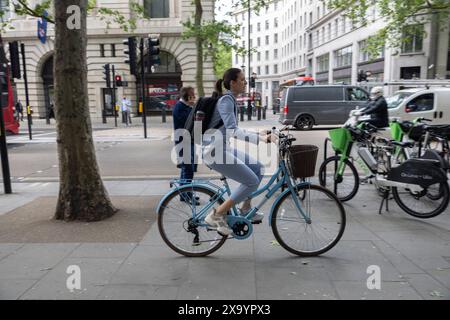 Junge Frau radelt auf dem Fußgängerweg in Aldwych, Zentrum von London, England, Großbritannien Stockfoto