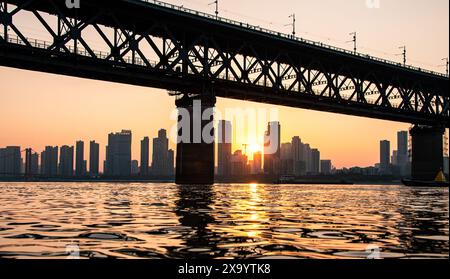 Die Wuhan Yangtze River Bridge unter Sonnenuntergang. Das Bild zeigt eine große Brücke mit Stahlrahmenkonstruktion. Stockfoto