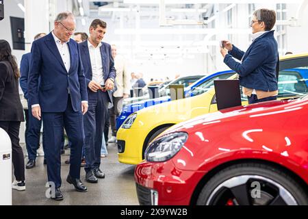 Wolfsburg, Deutschland. Juni 2024. Stephan weil (l, SPD), niedersächsischer Ministerpräsident, betrachtet Autos bei der Zeremonie „50 Jahre Golfproduktion“ im VW-Werk. Kredit: Moritz Frankenberg/dpa/Alamy Live News Stockfoto