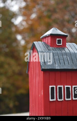 Red Barn Birdhouse vor herbstlichem Hintergrund Stockfoto