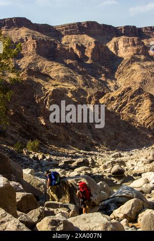 Zwei Wanderer, die durch den kargen Felsblock des Fish River Canyon in Südafrika navigieren Stockfoto