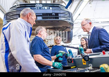 Wolfsburg, Deutschland. Juni 2024. Rainer Fessel (l), Werkleiter, erklärt dem niedersächsischen Ministerpräsidenten Stephan weil (SPD, r) vor der Zeremonie „50 Jahre Golfproduktion“ im VW-Werk die Produktion eines Volkswagen Golf. Kredit: Moritz Frankenberg/dpa/Alamy Live News Stockfoto