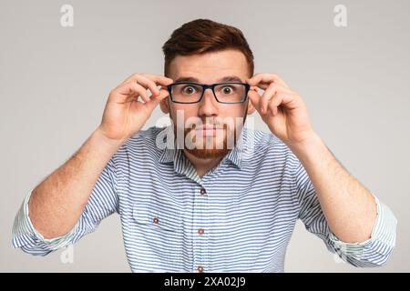 Jungen Mann, seine großen Augen zeigt, in Gläser Stockfoto