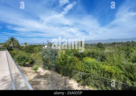 Ein malerischer Blick über ein grünes Tal von oberhalb eines Zauns in Encino, Kalifornien Stockfoto