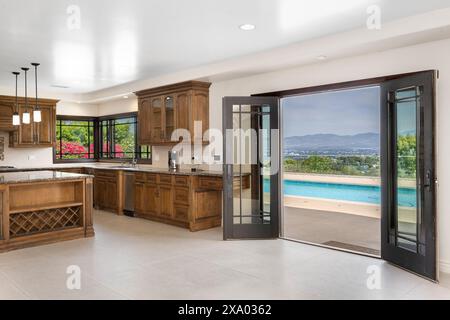 Eine moderne Küche mit Holzschränken und weißem Fliesenboden in Encino, Kalifornien Stockfoto