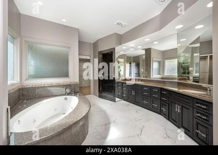 Ein geräumiges, weiß-graues Badezimmer mit Jacuzzi-Wanne durch Fenster in Encino, Kalifornien Stockfoto