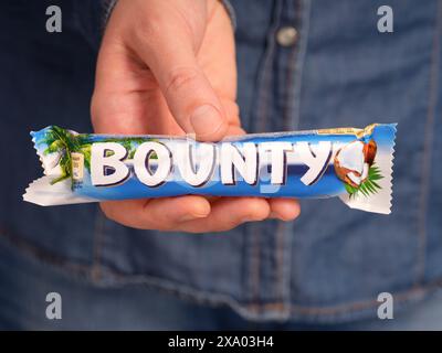 Tambow, Russische Föderation - 23. Januar 2024 Eine Frau, die Bounty Schokoladenriegel hält Stockfoto