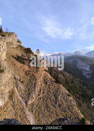 Der felsige Hang vor der Kulisse der Berge und des blauen Himmels Stockfoto
