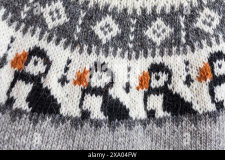 Nahaufnahme einer großen bunten Passe eines gestrickten grauen Lopeysa-Pullovers aus Wolle mit traditionellen isländischen Puffinvögeln Stockfoto