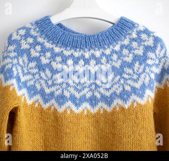 Nahaufnahme einer großen blauen, weißen, gelben Passe eines Strickpullovers aus Wolle in traditionellem isländischem Strickmuster Stockfoto