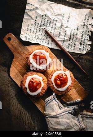 Die drei Runeberg Kuchen mit Schlagsahne und Himbeermarmelade auf Holzteller Stockfoto