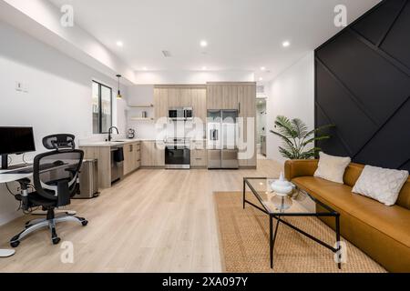 Modernes Wohnzimmer mit gelbem Sofa und weißem Essgarnitur Stockfoto