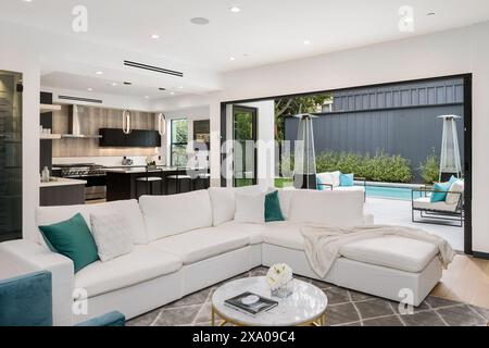 Modernes Wohnzimmer mit Sofas, Tischen und offenem Küchenkonzept Stockfoto