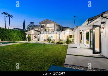 Ein Hinterhof mit üppig grünem Gras und zwei Swimmingpools auf jeder Seite Stockfoto