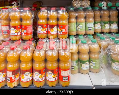 Italien - 01. Juni 2024: Pfirsichfruchtsäfte und Fruchtfleisch in Plastikflaschen in Regalen zum Verkauf in Discounter-Supermärkten Stockfoto