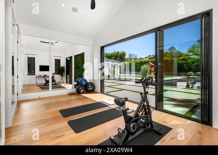 Ein voll ausgestatteter Fitnessraum mit Fitnessgeräten in der Ecke Stockfoto