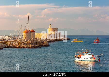 Windmühlen und Fort St. Nikolaus im Mandraki Harbour auf Rhodos Griechenland bei Sonnenuntergang Stockfoto