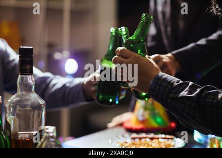 Eine Gruppe von Geschäftsleuten hält Bierflaschen und klirrt einander an, um den Erfolg ihres gemeinsamen Unternehmens zu feiern. Die Idee von ​​cele Stockfoto