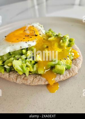 Ein köstliches offenes Sandwich mit Avocado und Spiegelei darauf Stockfoto