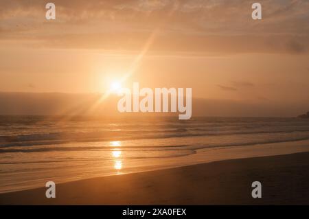 Warmer Sonnenuntergang am Strand in Montañita, Ecuador Stockfoto