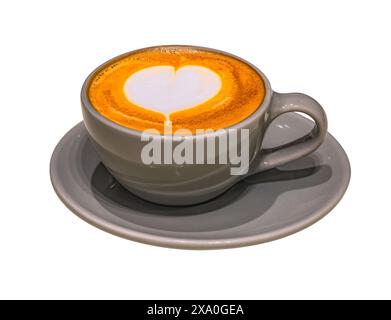 Isolierte Tasse Cappuccino mit einem hübschen herzförmigen Latte Art Design auf weißem Hintergrund serviert in einer eleganten grauen Keramikschale A Stockfoto
