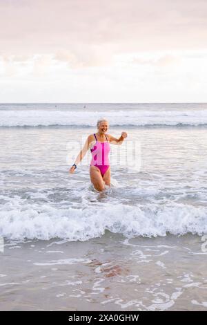 Europa, Spanien, Gipuzkoa, Zarautz Beach mit attraktiven älteren Frauen, die bei Sonnenaufgang baden Stockfoto