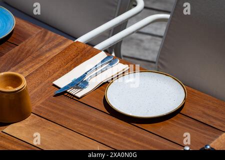 Vor dem Mittagessen wartet ein leeres, stilvolles Strandcafé mit Tischen im sonnigen Biarritz, Baskenland, Frankreich Stockfoto
