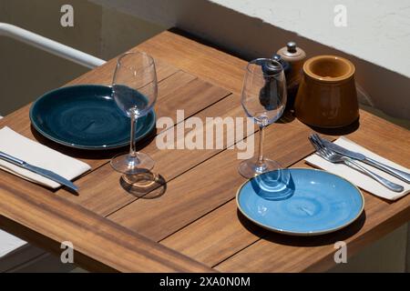 Vor dem Mittagessen wartet ein leeres, stilvolles Strandcafé mit Tischen im sonnigen Biarritz, Baskenland, Frankreich Stockfoto