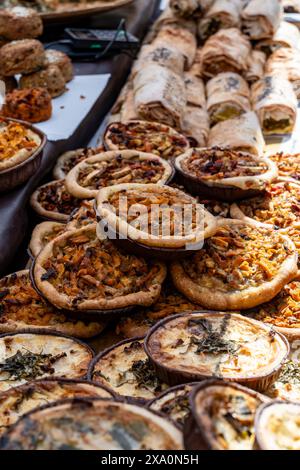 Leckeres vegetarisches Streetfood zum Mittagessen in London, verschiedene Quiche herzhafte Tarte mit Spinat, Tomaten, Pilzen, Cheddar-Käse, Nahaufnahme Stockfoto