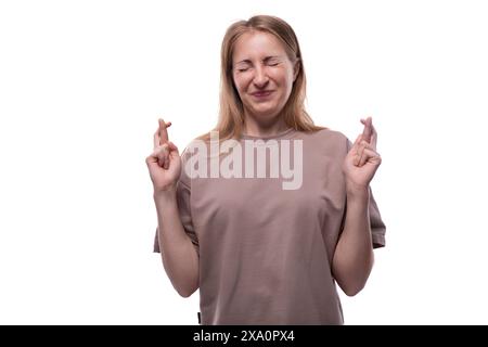 Porträt einer 40-jährigen Europäerin mit fließendem blondem Haar mit gekreuzten Fingern Stockfoto