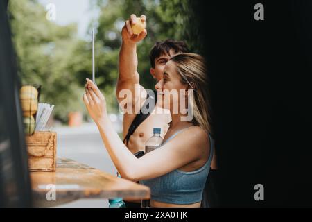 Sportpaare kaufen nach dem Training erfrischende Getränke am Stand im Freien Stockfoto