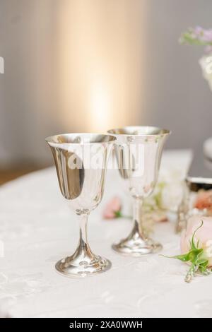 Ein dekorierter Hochzeitsempfangstisch mit Sektgläsern und Blumenarrangements Stockfoto