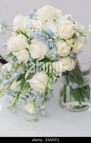 Eine Vase mit weißen und blauen Blumen auf einem Tisch Stockfoto