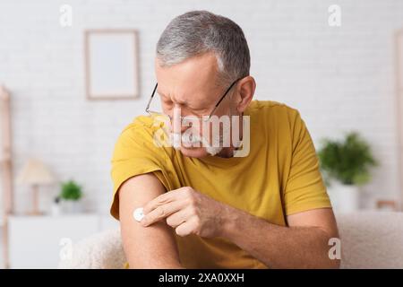 Seniorin mit Glukosesensor zur Messung des Blutzuckerspiegels zu Hause. Diabeteskonzept Stockfoto