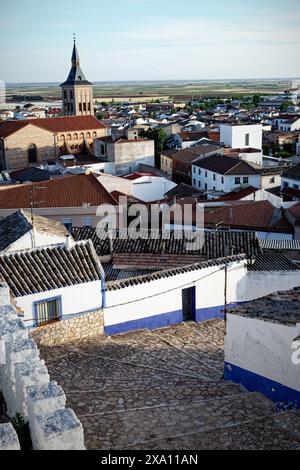 Der Blick auf die Iglesia de Nuestra Senora de la Asuncion mit anderen historischen Gebäuden. Campo de Criptana Stockfoto