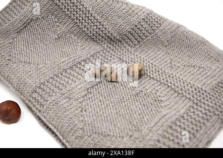 Nahaufnahme einer Textur einer braunen handgestrickten Wolldecke im Herzmuster auf weißem Hintergrund Stockfoto