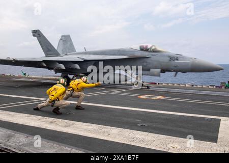 USS Ronald Reagan, Japan. Juni 2024. Schützen der US Navy signalisieren ein F/A-18E Super Hornet Jagdflugzeug, das an der Eagles of Strike Fighter Squadron 115 befestigt ist, um auf dem Flugdeck des nuklearbetriebenen Superträgers USS Ronald Reagan der Nimitz-Klasse während des Flugbetriebs am 3. Juni 2024 auf der Philippinischen See zu starten. Quelle: MC3 Kazia Ream/US Navy Photo/Alamy Live News Stockfoto