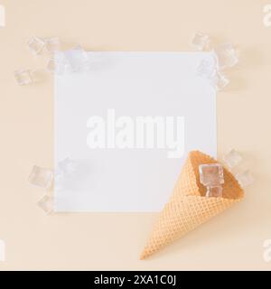 Kreatives, trendiges Layout mit Eiskegel, Eiswürfeln und Kopierbereich auf hellbeigem Hintergrund. Minimales Sommerkonzept. Flache Lagen. Stockfoto