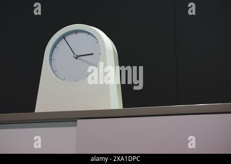 Eine Uhr auf einem Tisch mit dunklem Hintergrund Stockfoto