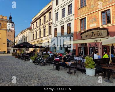 Eine Stadtstraße mit zahlreichen Tischen und Stühlen auf Kopfsteinpflaster im Stadtzentrum von Lublin, Polen Stockfoto
