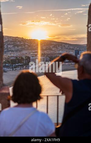 Paare genießen den Sonnenuntergang von den Stadtmauern des Schlosses Papa Luna in Peñiscola, Castellon, Valencianische Gemeinde, Spanien Stockfoto