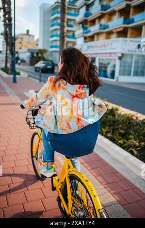 Frau fährt Fahrrad entlang der Promenade, Peñiscola, Spanien Stockfoto