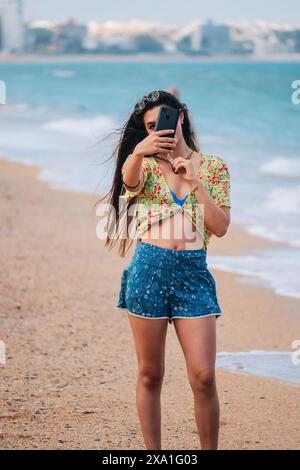 Junge Frau, die eine Selfie am Strand Stockfoto