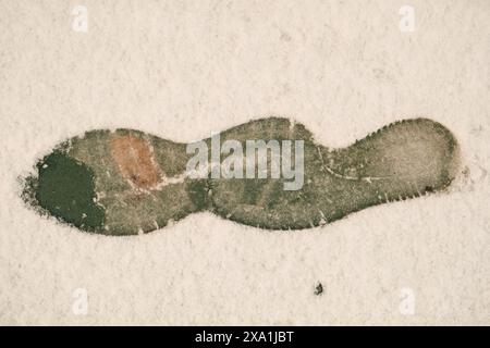 Eine Nahaufnahme von schmutzigen Fußabdrücken auf dem Boden, die von einer Person hinterlassen wurden Stockfoto