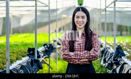 Asiatische Frau, die im Gewächshaus arbeitet Stockfoto