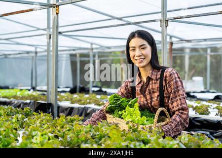 Asiatische Frau, die im Gewächshaus arbeitet Stockfoto