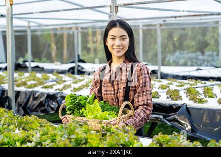 Asiatische Frau, die im Gewächshaus arbeitet Stockfoto